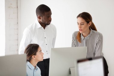 İşyeri bilgisayar ile konuşurken ciddi çok ırklı takım çözme iş sorun birlikte, çeşitli iş arkadaşları, beyin fırtınası veya işbirliği içinde office proje tartışan arkadaşları grup odaklı