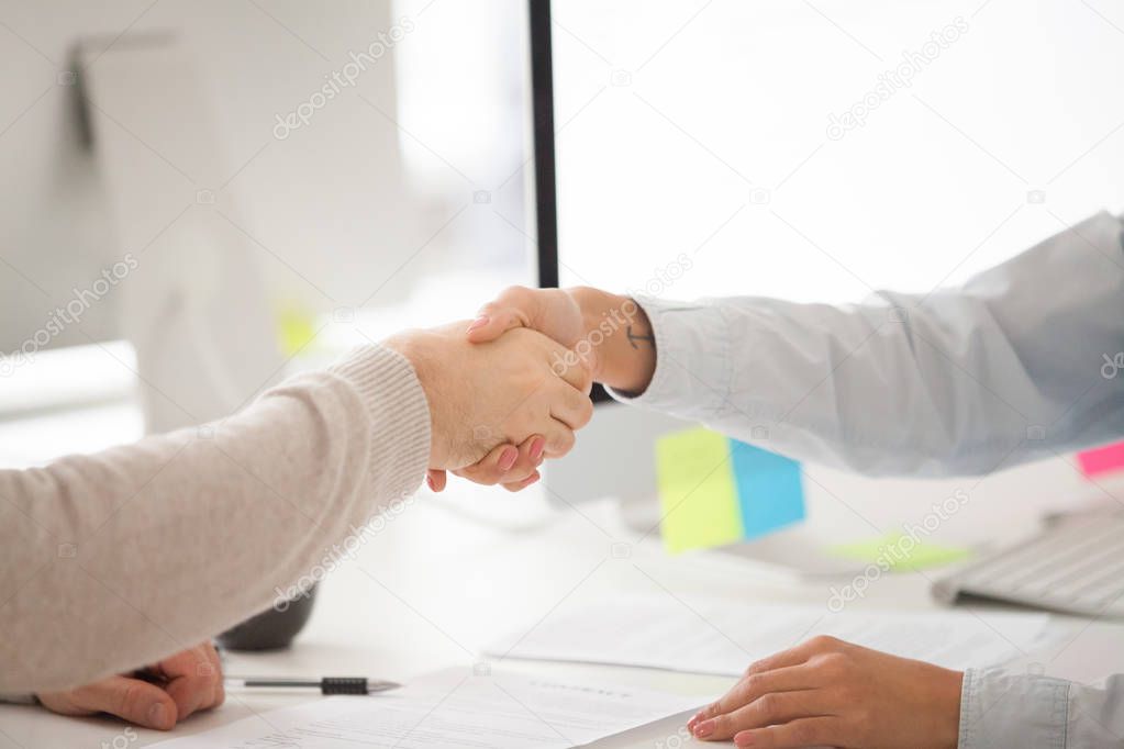 Businessman and businesswoman handshaking after signing contract