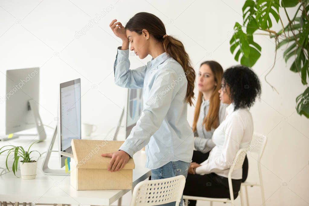 Upset fired dismissed young woman employee packing box leaving w