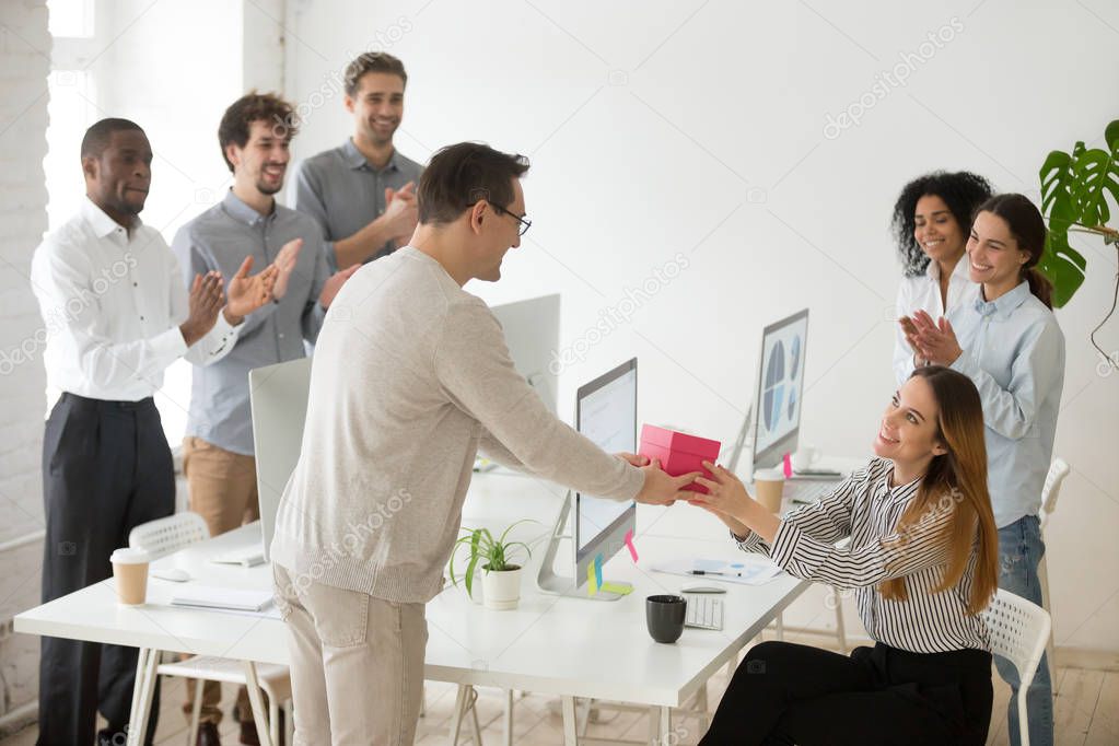 Friendly team congratulating female colleague with birthday gift
