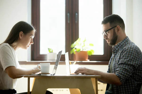 Work rivals looking at each other with jealousy and dislike