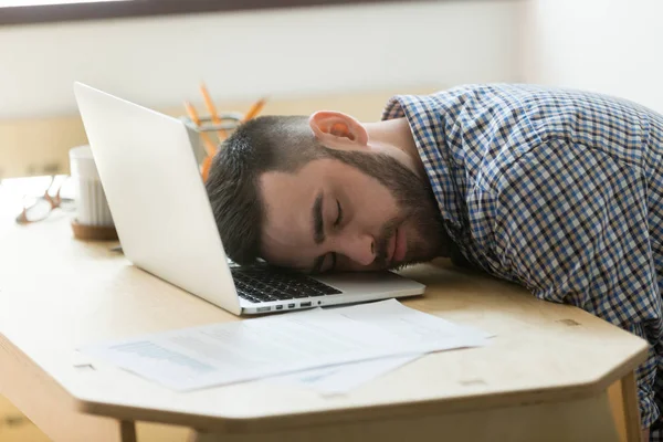 Trabajador varón cansado durmiendo en el portátil en el escritorio de la oficina —  Fotos de Stock