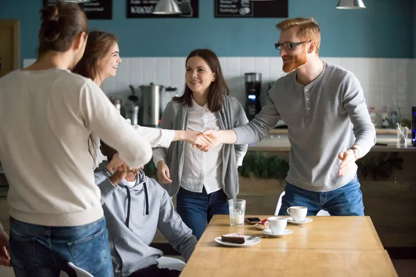 Millennial Guy Handshaking Smiling Girl Introducing Greeting Group Meeting Cafe — Stock Photo, Image