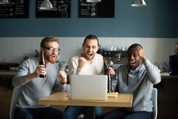 Multiracial män dricker öl firar seger tittar spelet — Stockfoto