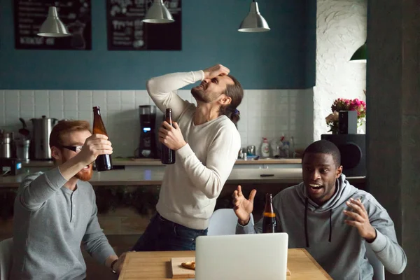 Disappointed diverse men shocked by losing watching game on lapt — Stock Photo, Image