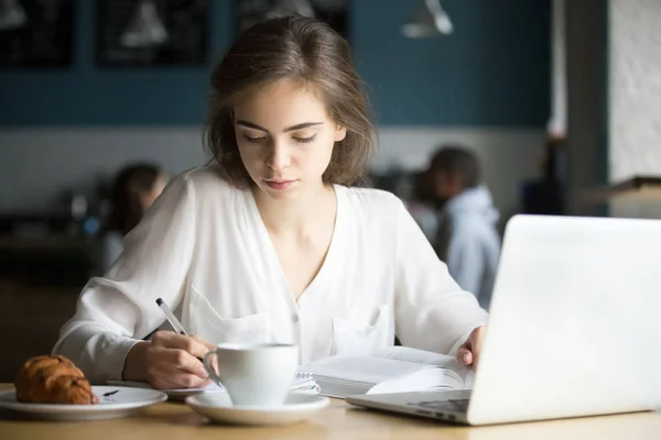 Fata serioasă studiază în cafenea făcând note pregătindu-se pentru examen — Fotografie, imagine de stoc