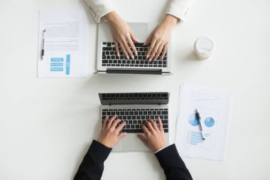 Dizüstü bilgisayarlarda yazarak iki ofis çalışanları üst görünümü kapatın