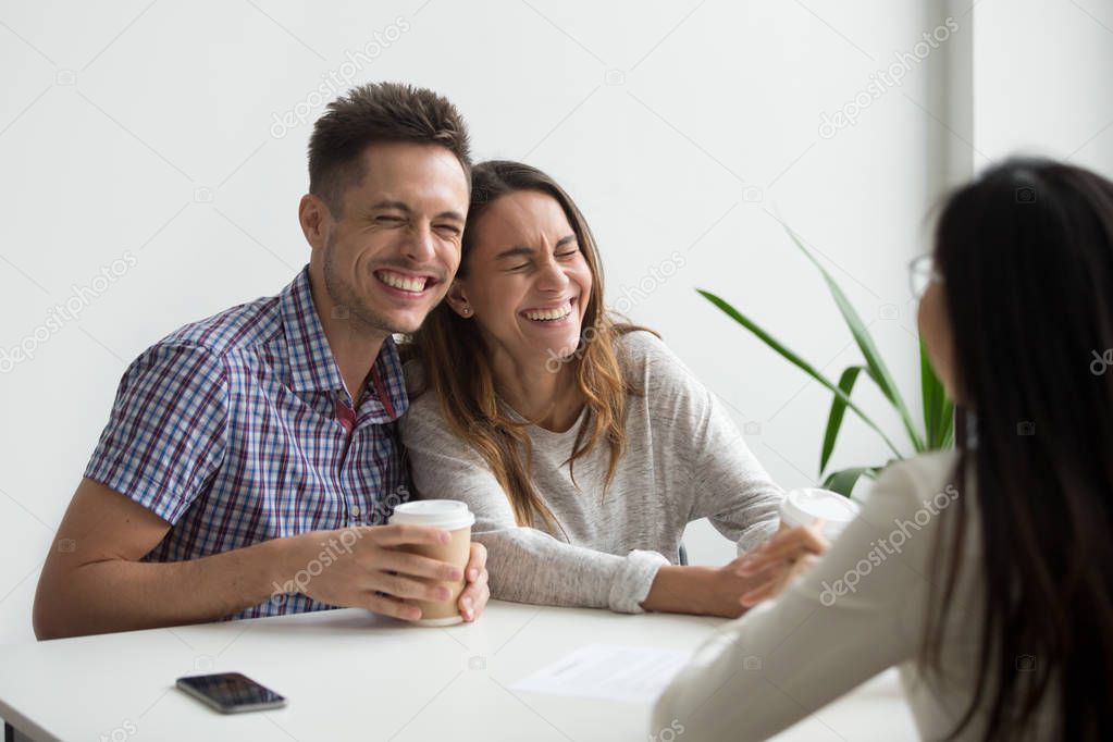 Happy couple clients laughing planning to sign contract at meeti