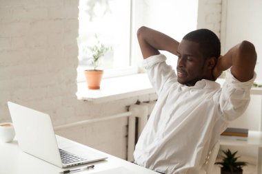 Geri sandalye rahatlatıcı eğilerek memnun Afro-Amerikan işçi