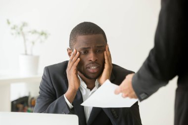 Upset African American worker getting dismissal notice  clipart