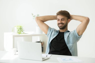 Memnun işçi iş tatilinde ofiste sandalyede rahatlatıcı