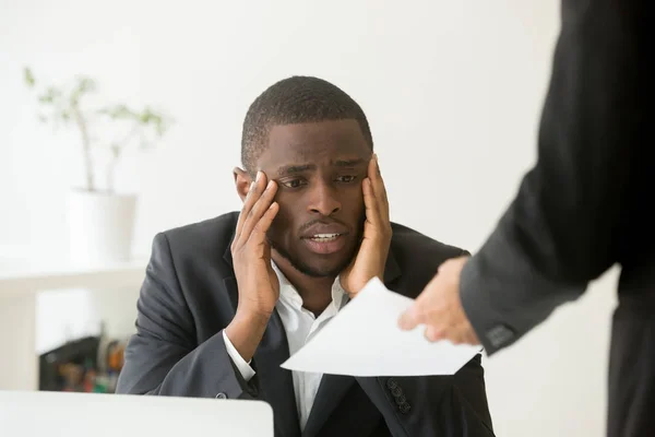 Расстроенный афроамериканский рабочий получает уведомление об увольнении — стоковое фото