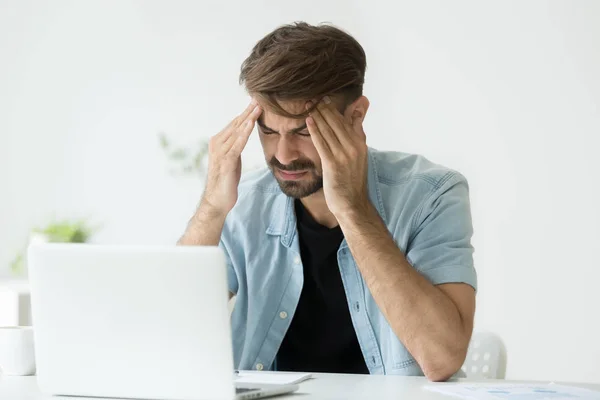 Trabajador cansado masajeando la cabeza que sufre de dolor de cabeza —  Fotos de Stock