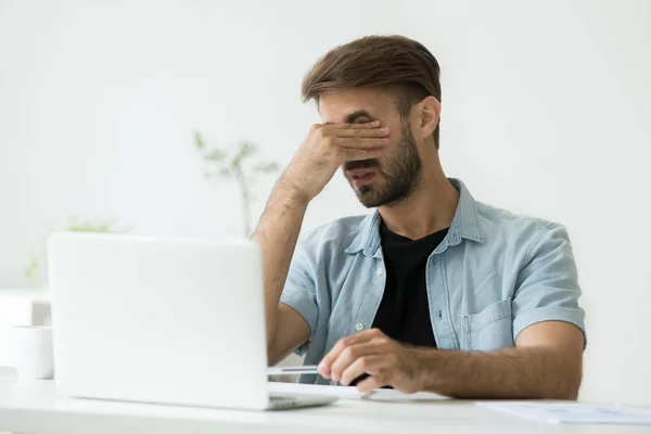 Tired worker massaging eyes suffering from headache — Stock Photo, Image