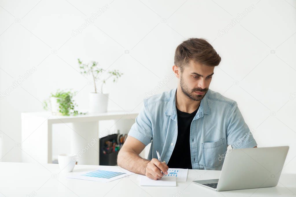 Serious manager working at laptop analyzing financial reports
