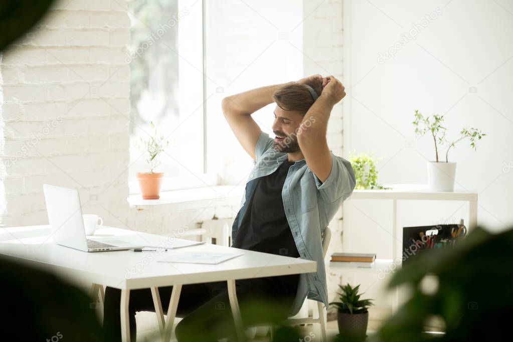 Happy worker in headphones listening to music and dancing