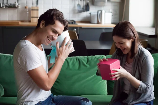 Emocionada pareja intercambiando regalos abriendo cajas con regalos en h — Foto de Stock