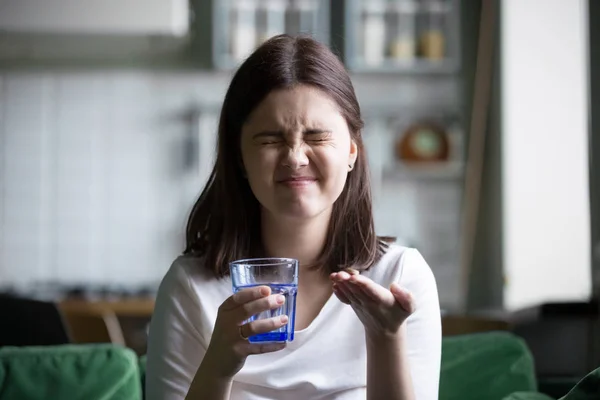 Frustrated stressed young woman grimacing afraid of taking pill — Stock Photo, Image