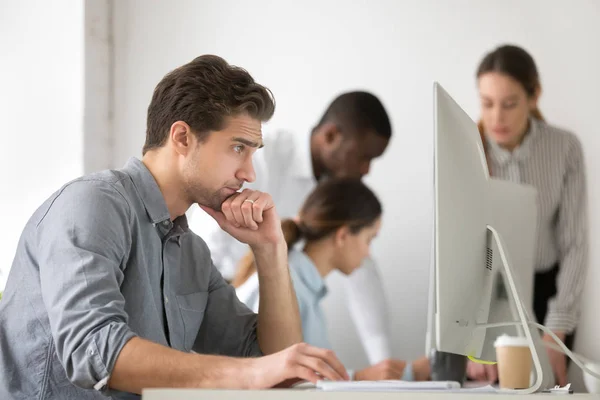 Nachdenkliche Mitarbeiter surfen im Web und lesen Finanznachrichten — Stockfoto