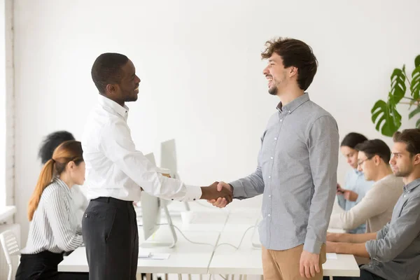 Empleador negro estrechando la mano de tímido macho caucásico trabajo solicitante — Foto de Stock