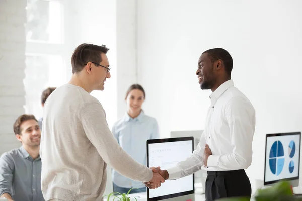 Boss shaking hand of black worker congratulating with promotion