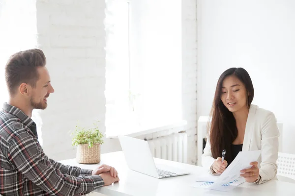 Female Asian employer mentoring male subordinate on financial is — Stock Photo, Image