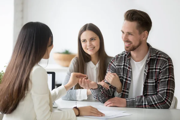 Smiling couple receiving keys to first apartment together — Stock Photo, Image
