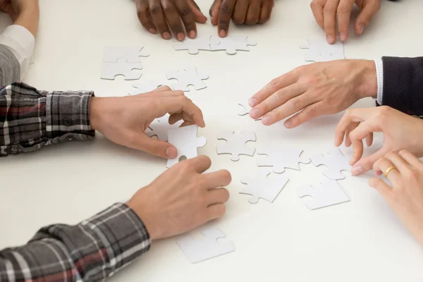 Equipo de trabajo diverso ensamblando rompecabezas en la actividad de trabajo en equipo — Foto de Stock