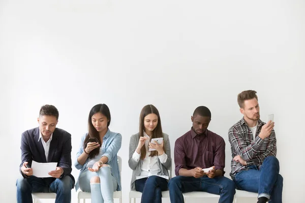 Multi-etnisch aanvragers voorbereiden op sollicitatiegesprek te wachten in qu — Stockfoto