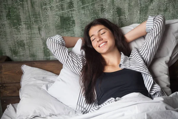 Sorrindo menina deitada na cama relaxante na manhã de fim de semana preguiçoso — Fotografia de Stock