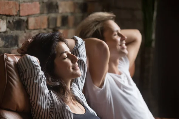 Happy couple daydreaming resting on couch during weekend — Stock Photo, Image