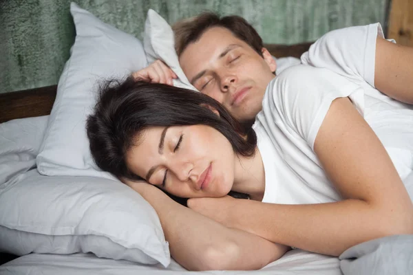 Millennial couple peacefully sleeping in cozy bed