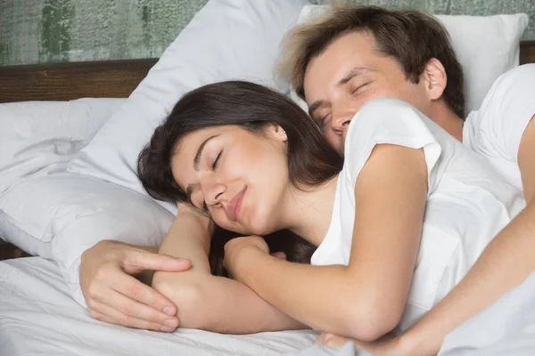 Boyfriend and girlfriend hugging asleep in cozy bed — Stock Photo, Image