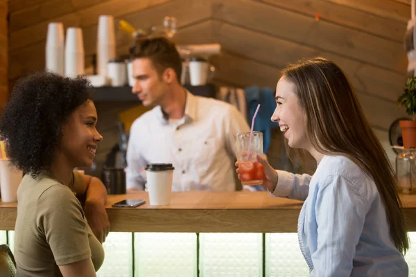 Multiracial girlfriends laughing, enjoying drinks at bar counter — Stock Photo, Image