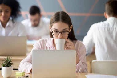 Ciddi kadın işçiye laptop çalışırken kahve keyfi
