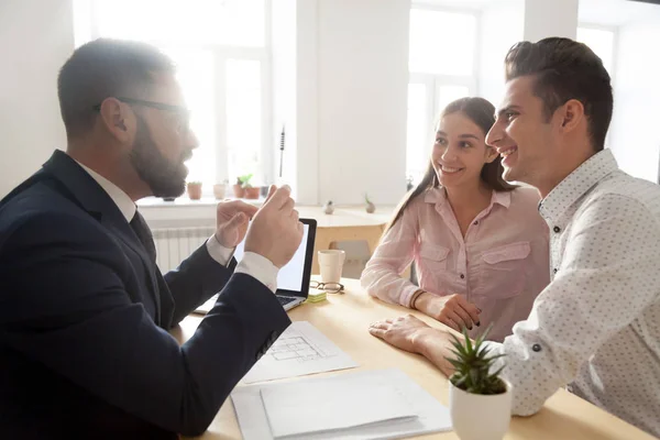 Arquitecto masculino discutiendo proyecto de casa con pareja joven —  Fotos de Stock