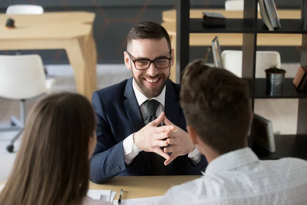 Lächelnder Makler, der Kunden im Büro berät — Stockfoto