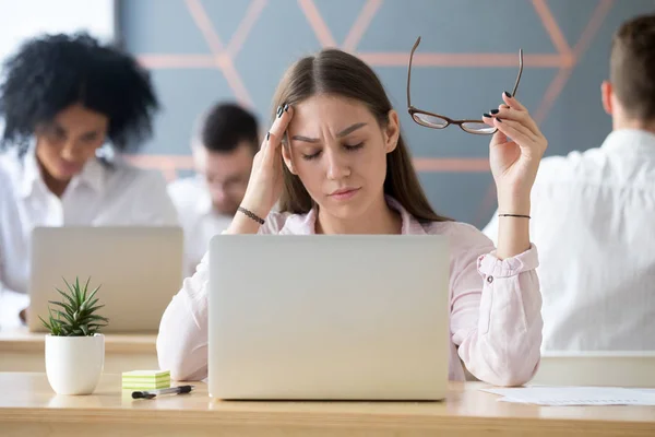 Empleada cansada que sufre dolor de cabeza en el lugar de trabajo — Foto de Stock