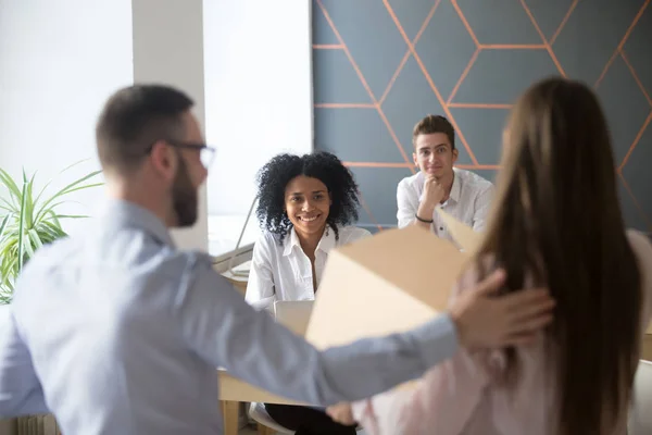 Emocionados colegas multirraciales dando la bienvenida a nuevo empleado en la oficina — Foto de Stock