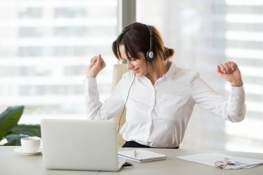 Mutlu kadın işçi ofis koltuğu dans müzik dinlemek