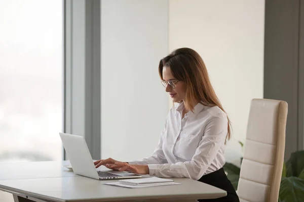 Успішна бізнес-леді працює в ноутбуці в офісі — стокове фото