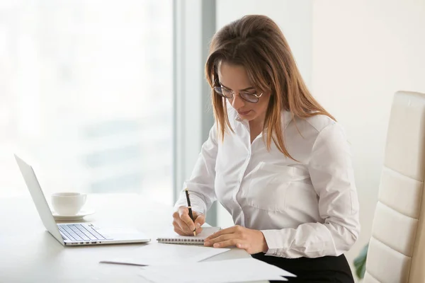 Ernstige zakenvrouw, het maken van notities tijdens routinematige office ochtend — Stockfoto