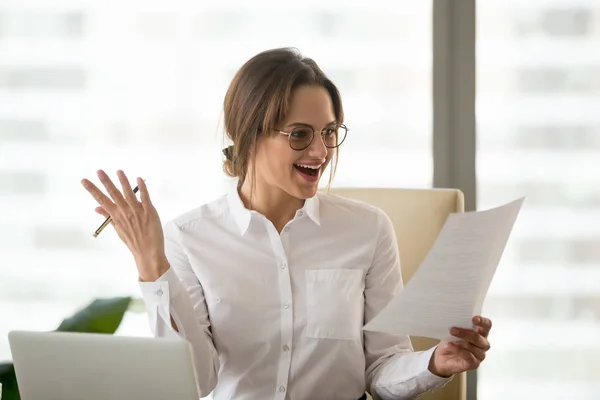 Возбужденная деловая женщина счастлива читать успешную статистику компании — стоковое фото