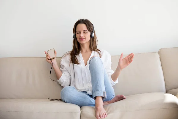 Excited millennial woman enjoying favorite hits on smartphone — Stock Photo, Image