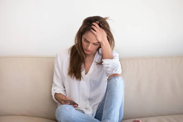 Chica triste sosteniendo teléfono inteligente esperando el mensaje de su novio — Foto de Stock