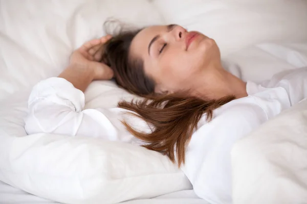 Calma joven mujer durmiendo en la acogedora cama blanca relajante — Foto de Stock