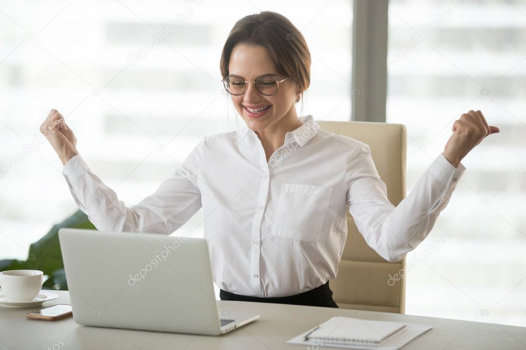 Excited female boss watching company online success at laptop