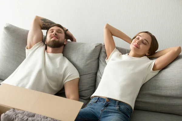 Relaxed couple lying on sofa happy to move in — Stock Photo, Image