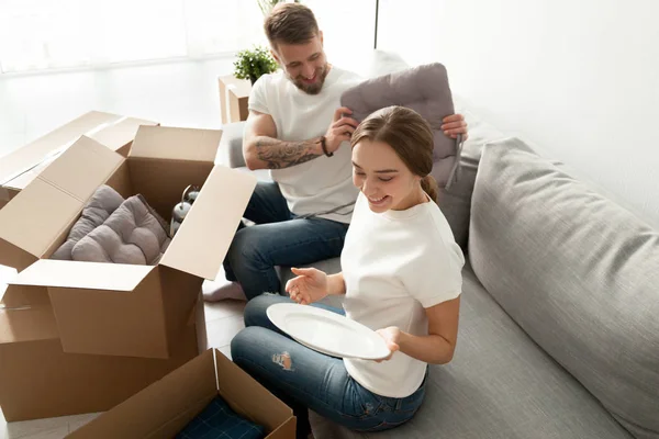 Hausbesitzer packen Kisten auf gemütlichem Sofa aus — Stockfoto