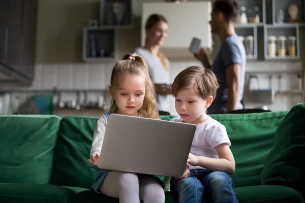 Lindos niños hermana y hermano sosteniendo portátil viendo en línea — Foto de Stock